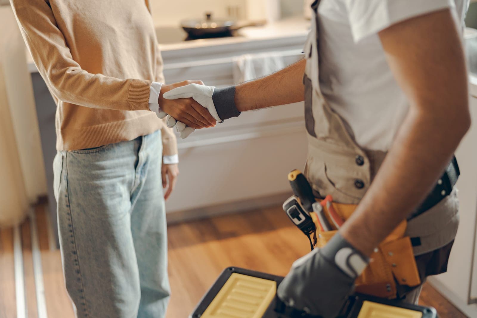 A Reinhardt HVAC technician shaking hands with a happy homeowner