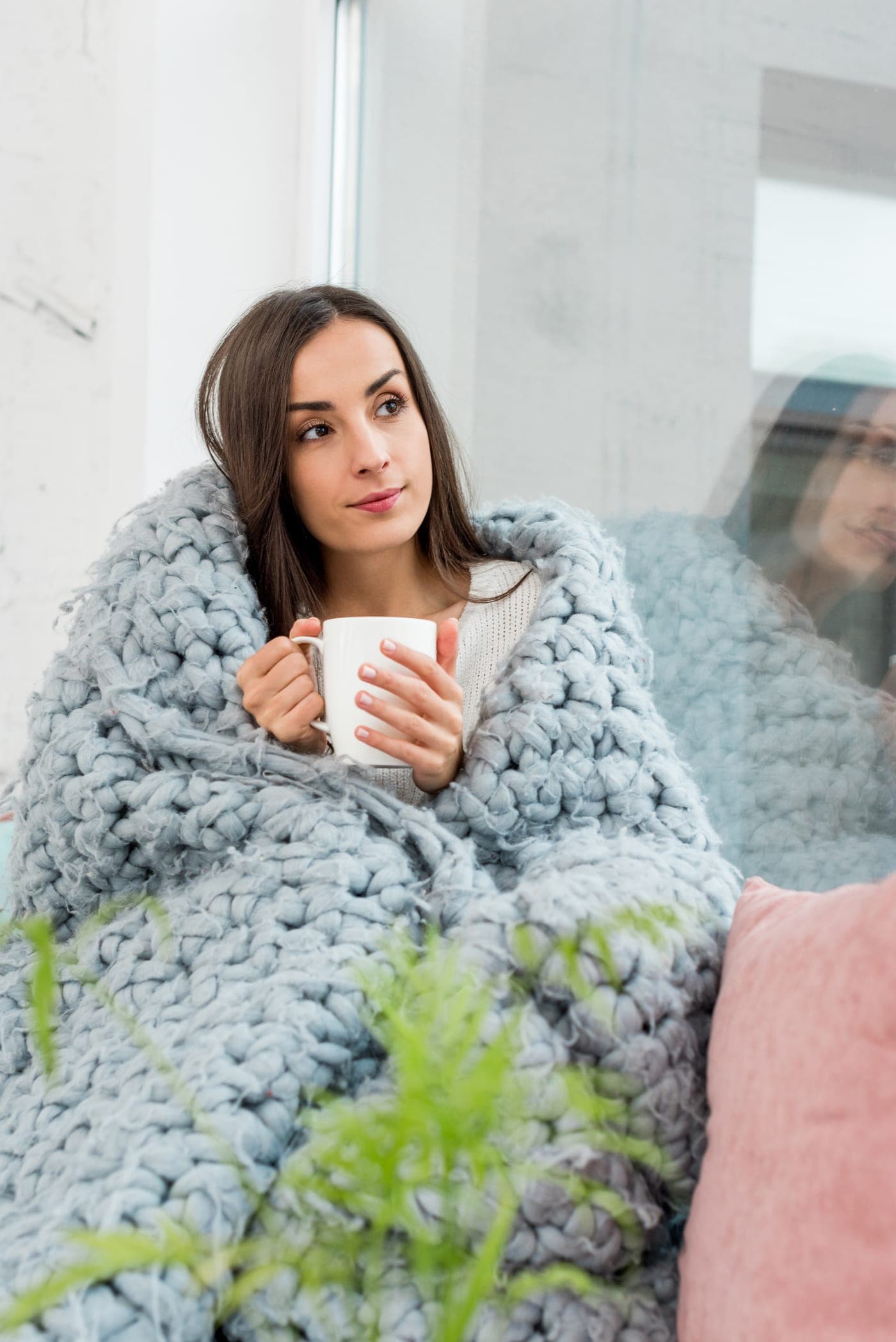 A homeowner adjusting a thermostat on a cold winter day