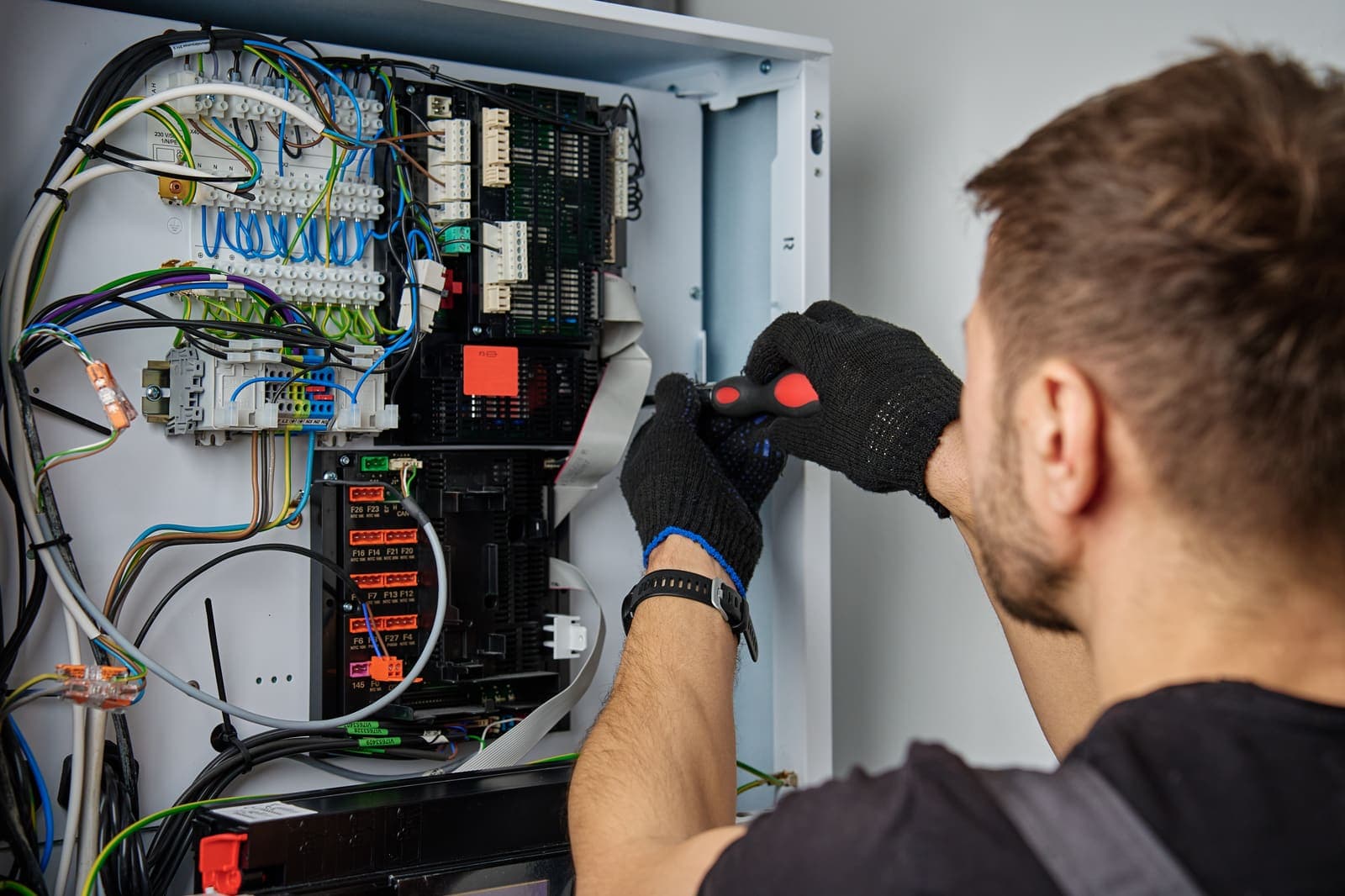 A technician checking the wiring and controls inside a home furnace