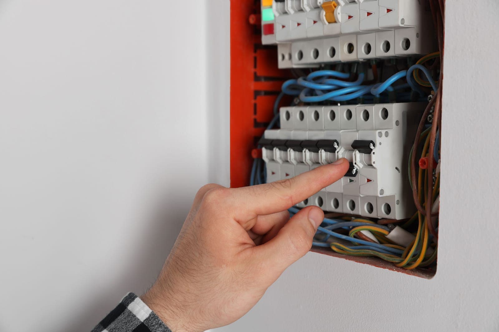 A hand resetting a circuit breaker in a home electrical panel