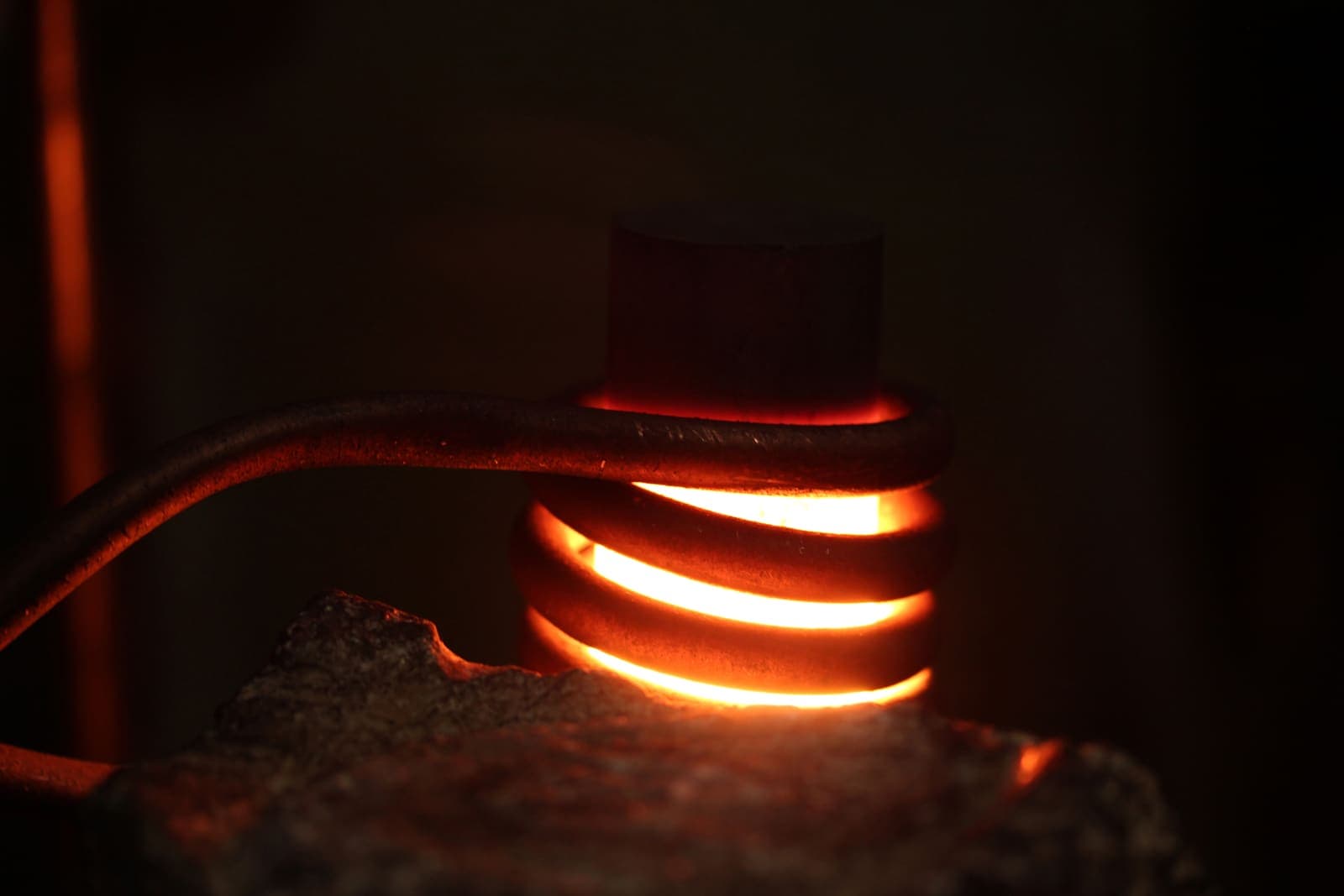 A metal heating coil glowing orange in a dark setting