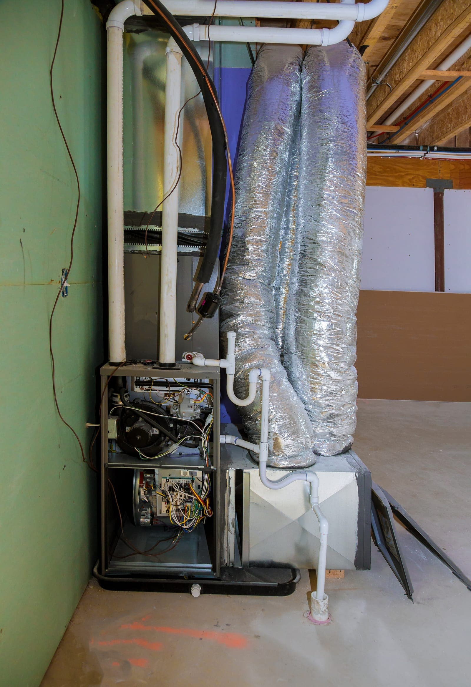 A residential furnace with ductwork installed in a home utility area