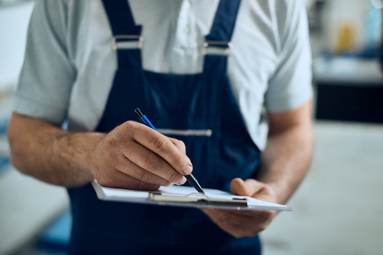 A technician filling out a maintenance checklist on a clipboard
