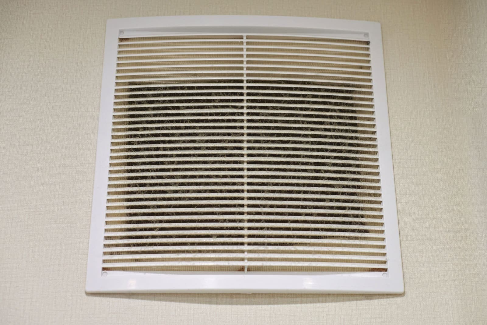 A large air return grille mounted on a wall inside a home