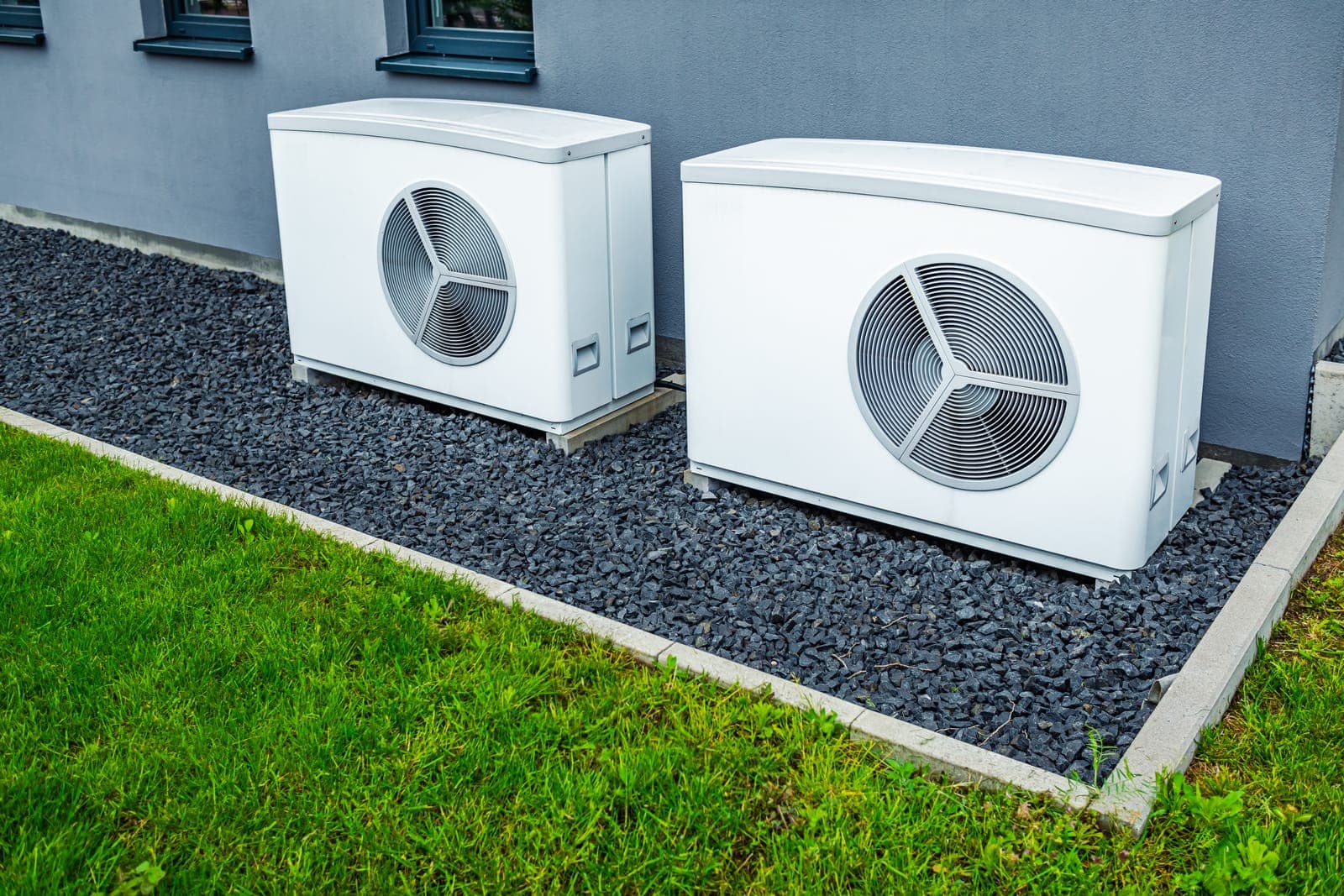 Two new air conditioning units installed outside a modern home