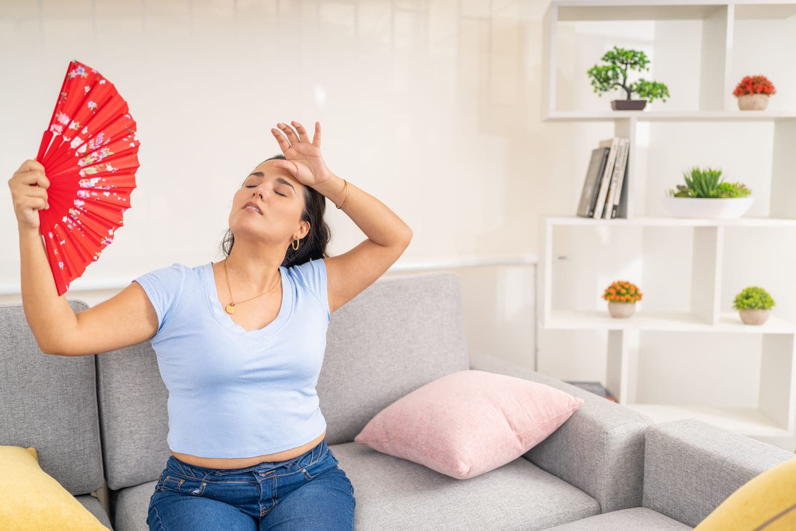 A person feeling warm at home during a hot summer day
