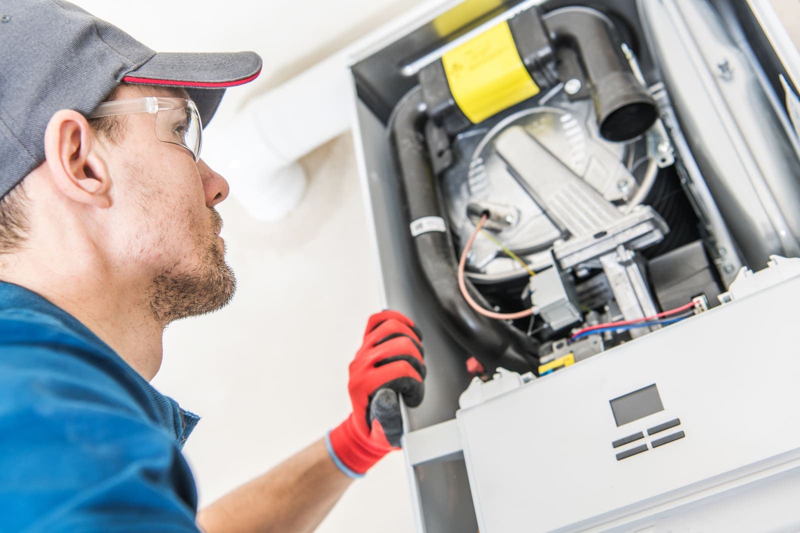 An HVAC technician repairing a home heating system