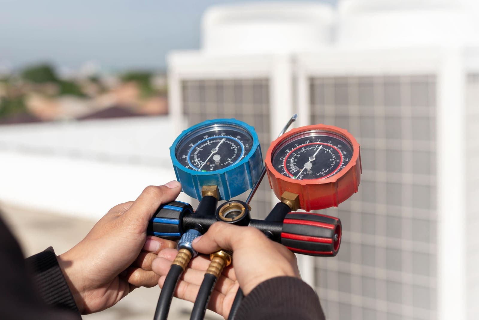 An HVAC technician using manifold gauges during a tune-up